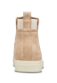 Bruna läderankleboots med krämfärgade elastiska paneler, en dragflik bak och en vit gummisula. Har prägling med logotypdetalj.