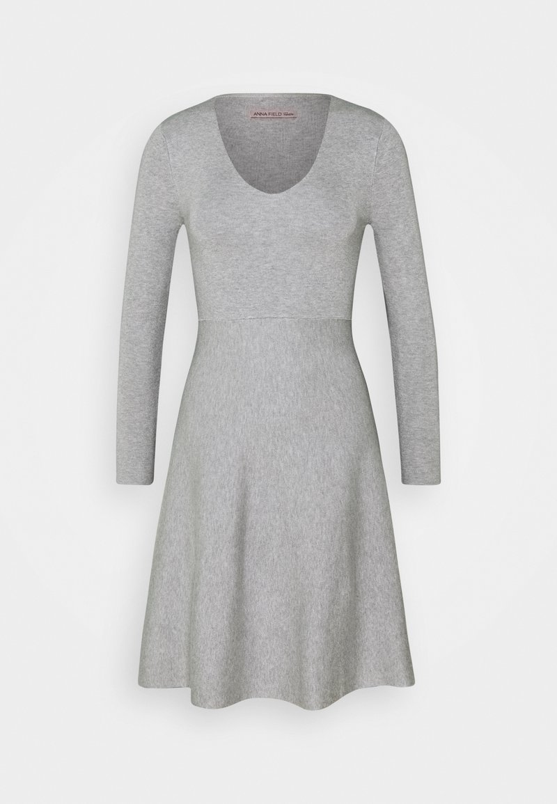 Robe en maille gris clair à manches longues avec encolure dégagée et taille cintrée, s'évasant en une jupe trapèze.