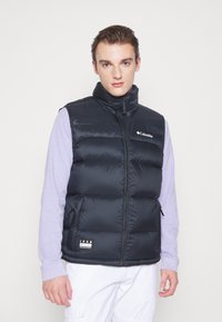 Černá péřová vesta s vysokým límcem, zipovým uzávěrem a bočními kapsami. Na hrudi je logo a na lemu štítek. Hladká textura.