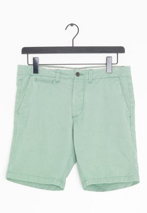 Jasnozielone szorty wykonane z bawełny, z dwiema przednimi kieszeniami, zapięciem na guzik, szlufkami na pasek i przeszywanym dołem.