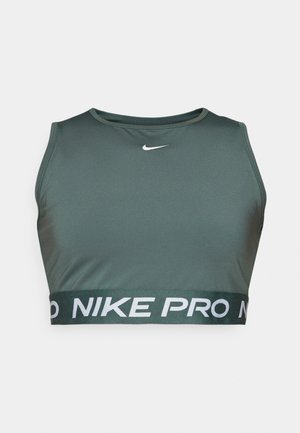 Sujeción deportiva verde hecho de una tela suave, con un escote redondo y una banda elástica ancha con "NIKE PRO" en letras blancas.