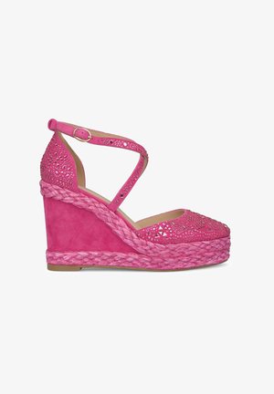 Pink wedge sandal with cutout design and rhinestone accents. Features braided jute platform and ankle strap for secure wear.
