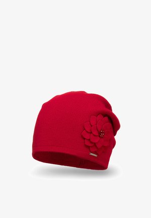 Punainen neulepipo, jossa on teksturoitu pinta, ja sivussa huopakukka-akcentti sekä pieni metallinen logotagi.