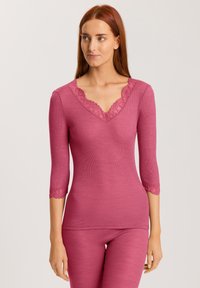 Maglietta a maniche lunghe in tessuto a costine rosa con merletto lungo il collo a V e maniche a tre quarti, caratterizzata da una silhouette aderente.