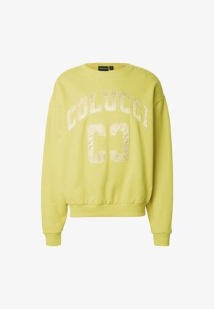 Helevalge kollane dressipluus, mille rinnal on suured läikivad tähed "COLUCCI" ja "C3", soonikulised varrukasääred ja vöökoht.