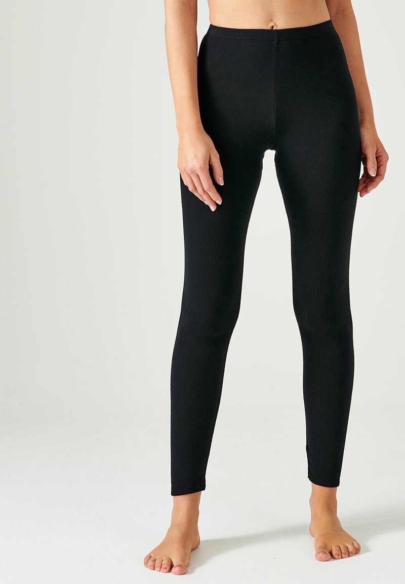 Zwarte leggings van rekbaar materiaal, met een hoge tailleband, aansluitend ontwerp, zachte textuur en enkellange snit.