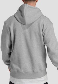 Gray cotton hoodie with a drawstring hood, ribbed cuffs, and hem. Textured fabric visible, featuring a relaxed fit and no visible patterns.