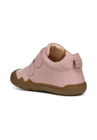 Chaussure pour enfant rose en cuir lisse, dotée de bandes auto-agrippantes, d'un bout arrondi et d'une semelle en caoutchouc marron avec des bords en zigzag.