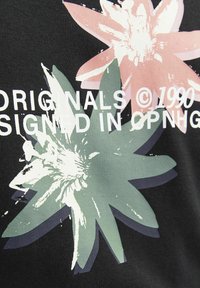 Tela de algodón negra con gráficos de flores en rosa y verde, con un acabado texturizado. Texto "ORIGINALS ©1990 FIRMADO EN CPNHG" en blanco.