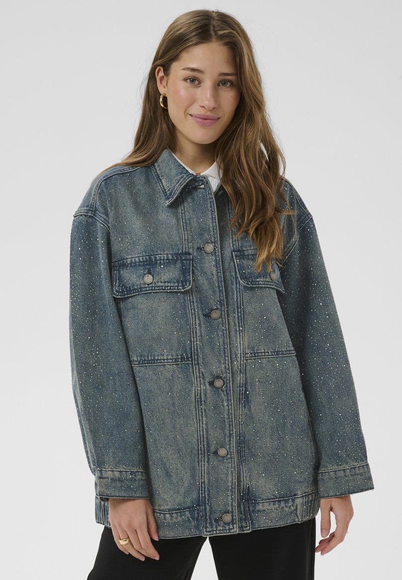 Jeansjacke in ausgeblichenem Blau mit übergroßem Schnitt, silbernen Punktakzenten, zwei Brusttaschen und vorderer Knopfleiste. Lange Ärmel und stabiler Kragen.