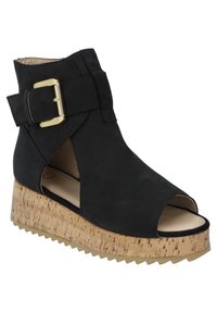 Black wedge sandal with an open toe and side cutouts, featuring a prominent gold buckle and a textured cork-like platform.