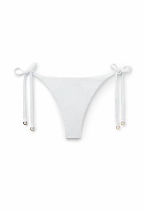 Slip bikini bianchi con laccetti laterali regolabili con piccoli anelli dorati su uno sfondo bianco semplice.