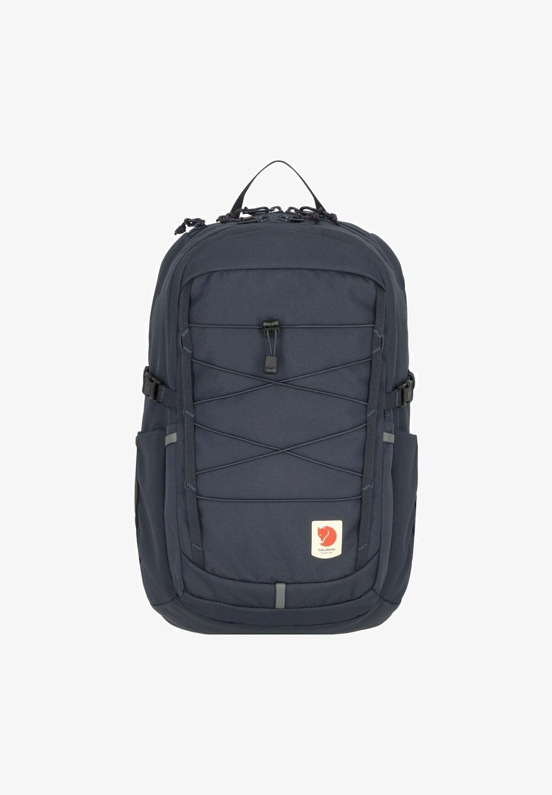 Zaino blu navy con una trama liscia, dotato di un sistema di corda elastica sulla parte anteriore, tasche laterali e una toppa con logo sulla parte anteriore inferiore.