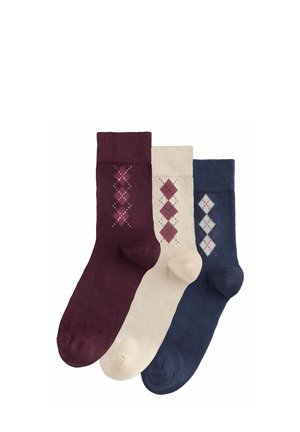 Drie paar sokken in bordeaux, crème en navy. Elk paar heeft een ruitpatroon in contrasterende kleuren op het been.