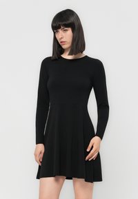 Black long-sleeve dress with a fitted bodice and flared skirt. Made from smooth fabric, featuring a round neckline and subtle seam detailing.