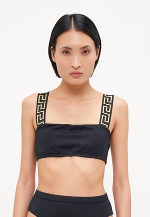 Black cropped bikini top with wide straps featuring a gold geometric pattern. Smooth fabric and straight neckline create a simple design.