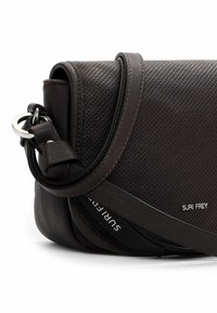 Borsa a tracolla in pelle marrone con texture perforata, hardware in argento e un accento del logo sul lato. Include una tracolla regolabile.