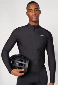 Black long-sleeve cycling jersey with full zipper, paired with a black vented helmet, showcasing a sleek design and athletic fit.