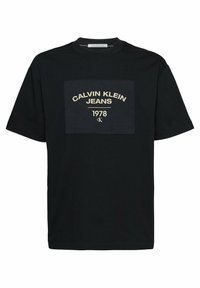 Černé bavlněné tričko s kontrastní obdélníkovou nášivkou loga s nápisem "CALVIN KLEIN JEANS 1978" ve zlaté barvě. Krátké rukávy a kulatý výstřih.