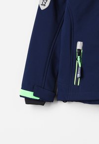 Navy blue softshell jacket with neon green accents; features a zip pocket, elastic cuffs, and a textured woven fabric.