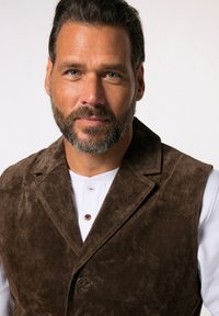 Braune Wildlederweste mit Reverskragen, einreihigem Knopfverschluss und strukturierten Oberfläche, getragen über einem weißen Henley-Shirt.