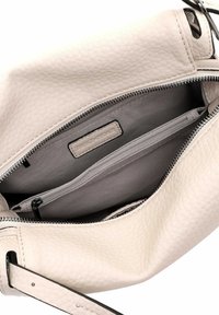Light beige leather handbag with a textured surface, silver zip, and two interior pockets. Black strap accents the opening.