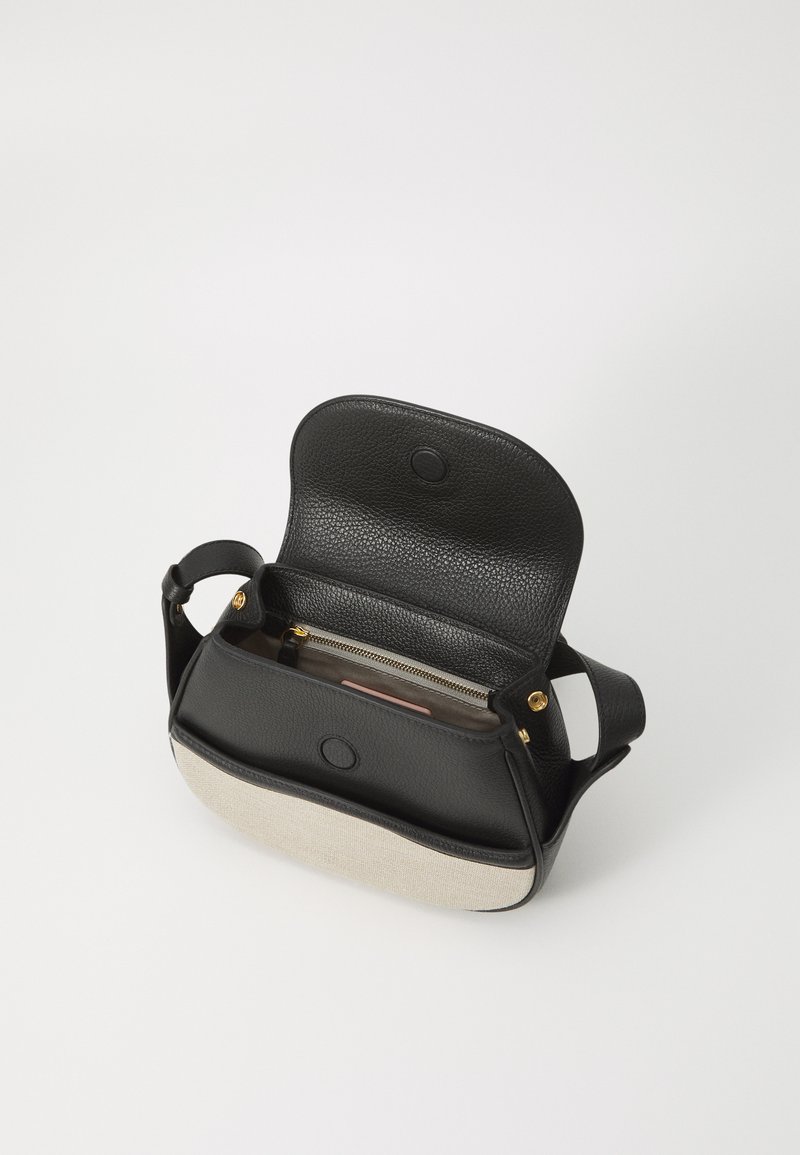 Schwarze Leder-Crossbody-Tasche mit einem beige Stoffboden. Sie verfügt über einen umklappbaren Deckel, goldene Beschläge und eine innere Reißverschlusstasche.