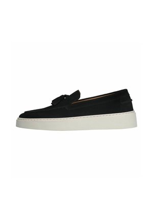 Black suede slip-on shoes with a rounded toe, tassel detail, and a white thick sole. Features stitching along the sole.