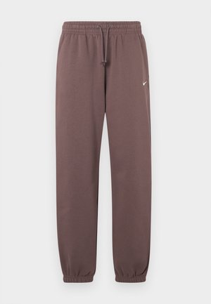 Καφέ Nike φόρμες με ελαστική μέση, κορδόνι, μανσέτες στους αστραγάλους και μικρό λευκό λογότυπο Nike στο άνω αριστερό πόδι.