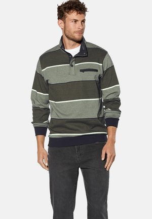 Dunkelgrüner gestreifter Pullover mit Kragen, der weiße und hellgrüne horizontale Streifen aufweist und eine Brusttasche mit Reißverschluss hat. Das Material hat eine strukturierten Oberfläche.