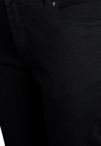 Jeans in denim nero con una texture liscia, design aderente e stile classico a cinque tasche. Presentano una chiusura frontale con bottone e cuciture sottili.