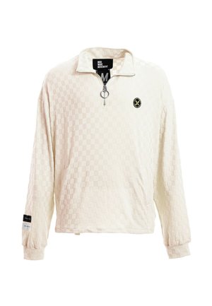 Jersey de manga larga de textura cremosa con cremallera hasta un cuarto y tirador en forma de anilla, puños acanalados, pequeño logo redondo en el pecho y etiqueta en la manga izquierda.