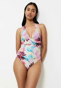Bañador de una pieza floral en beige con pétalos en rosa, azul y púrpura. Diseño de cuello halter, escote en V profundo y detalle fruncido en la cintura.