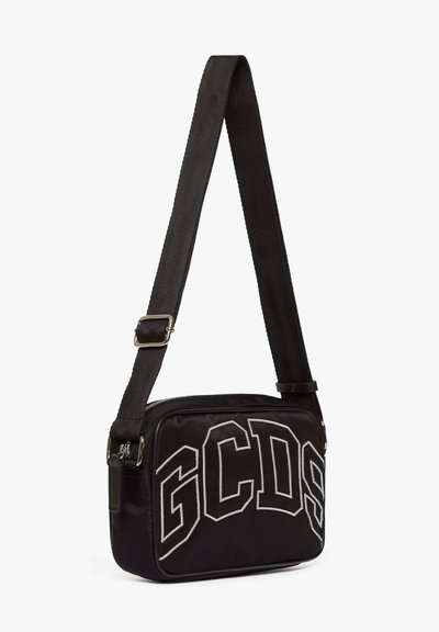 Svart nylon axelremsväska med justerbar rem, prydd med vit "GCDS" brodyr och silverfärgade detaljer, rektangulär form, slät textur.
