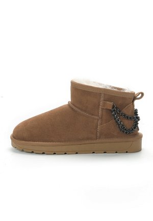 Stivaletto in suede marrone con fodera in pelliccia, punta rotonda e un accento decorativo a catena sul lato. Presenta una suola in gomma texturizzata.