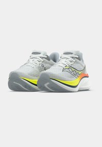 Grey mesh athletic shoes with white laces, yellow and orange accents, cushioned soles, and patterned surface texture.