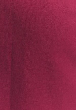 Głęboki magenta materiał o gładkiej strukturze i drobnym wzorze dzianiny, ukazujący subtelne zmiany koloru i światła.