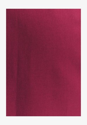 Dziļa magentas krāsa ar gludu tekstūru un smalku adījumu, parādot niansētas krāsu un gaismas variācijas.