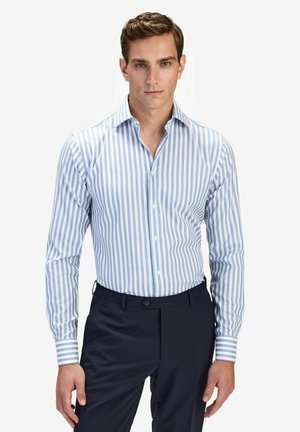 Light blue and white striped dress shirt with a pointed collar, long sleeves, and button front; paired with dark pants.