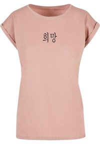 Hele roosa T-särk l�ühikeste rullitud varrukatega ja ümmarguse kaelusega. Keskel on must tekst korea keeles. Pehme, mugav kangas.
