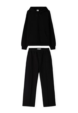 Black hoodie with a front pocket and drawstring hood, paired with matching black wide-leg trousers featuring a relaxed fit and side pockets.