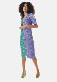 Floral-print dress with a deep V-neck, short puff sleeves, and a split hem; one side is green with patterns, the other is blue with abstract designs.