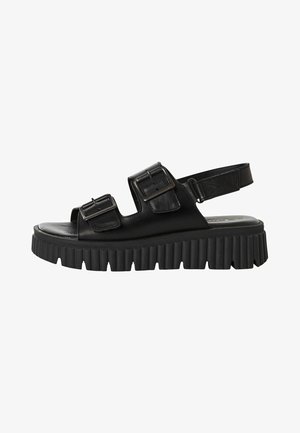 Svarta lädersandaler med två justerbara remmar med spännen, ett slingback-design och en tjock, texturerad gummisula.