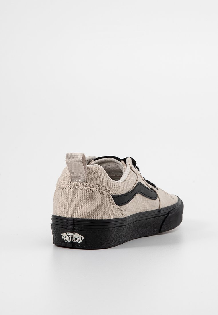 Baskets en toile beige avec des accents noirs sur les côtés, bout rond et semelle en caoutchouc. Présentent une languette au talon pour un enfilage facile et un logo de marque sur la semelle.