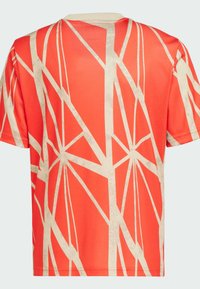 Camisa de manga corta en un brillante color naranja con patrones geométricos en crema que parecen líneas superpuestas. Textura suave y cuello redondo.