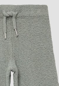 Hellegraue, strukturierte Sweatpants mit einem elastischen Bund und Kordelzug, ausgestattet mit silberfarbigen Metallspitzen. Keine sichtbaren Taschen.