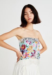 Strapless cropped top in lichtblauw, voorzien van meerkleurige bloemenborduursels en zilveren paillettenrand met franjes aan de onderrand.
