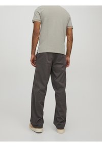 Szary t-shirt z kontrastowym wykończeniem, w połączeniu z luźnymi, ciemnoszarymi spodniami, wykonanymi z miękkiej bawełny. Casualowy design, luźny krój.