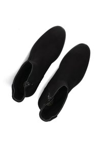 Zwarte suède enkellaarsjes met een ronde neus, zijritssluiting en subtiele decoratieve stiksels. Stevige textuur en middelhoog ontwerp.