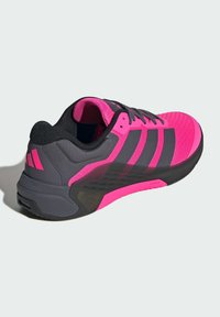 Αθλητικό παπούτσι με ροζ επάνω μέρος, μαύρες λεπτομέρειες και υφασμένο σχέδιο. Διαθέτει μαλακό πάτο και τρεις μαύρες ρίγες στο πλάι.